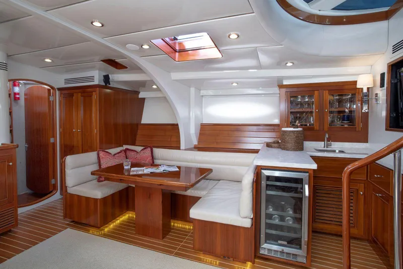 Slide: The Image of Luxurious yacht interior with wooden finishes, dining area, and kitchenette. Able Custom 97', 1993 model. - 13
