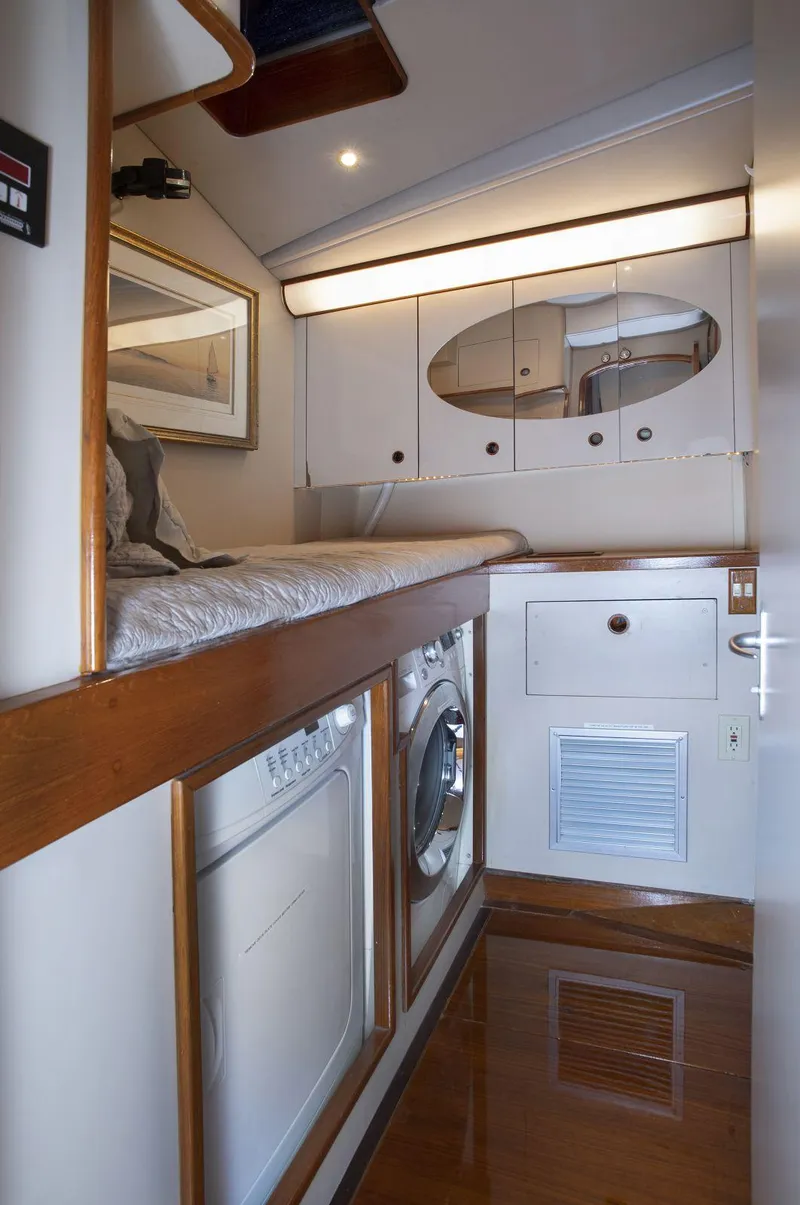 Slide: The Image of Laundry area in a 1993 Able Custom 97' yacht with washer, dryer, and storage cabinets. - 16