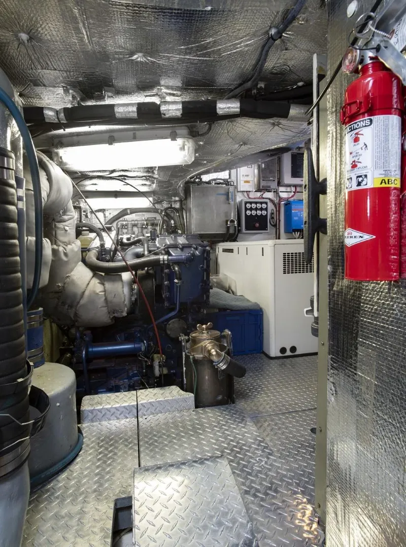 Slide: The Image of Engine room of a 1993 Able Custom 97' with fire extinguisher and control panels. - 24