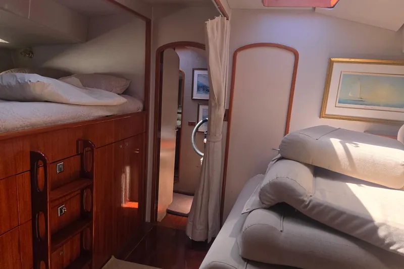 Slide: The Image of Interior of a 1993 Able Custom 97' yacht with cozy bedding and elegant wood finishes. - 33