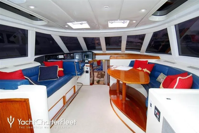 Slide: The Image of Luxurious yacht interior with blue seating, wooden table, and vibrant cushions, 1993 Able Custom 97'. - 8