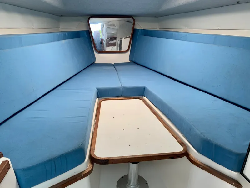 Slide: The Image of 2003 Contender 35 Express Side Console interior with blue seating and table. - 21