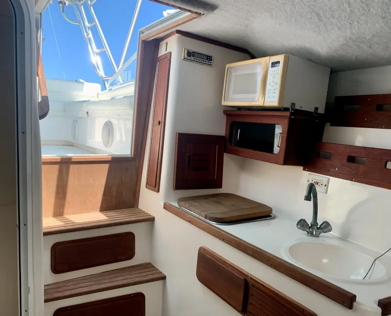 Slide: The Image of Interior of 2003 Contender 35 Express Side Console with kitchenette and stairs. - 23