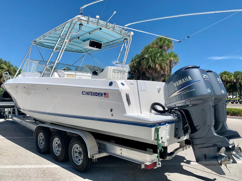 Slide: The Image of 2003 Contender 35 Express Side Console boat with Yamaha outboard engines on a trailer. - 27