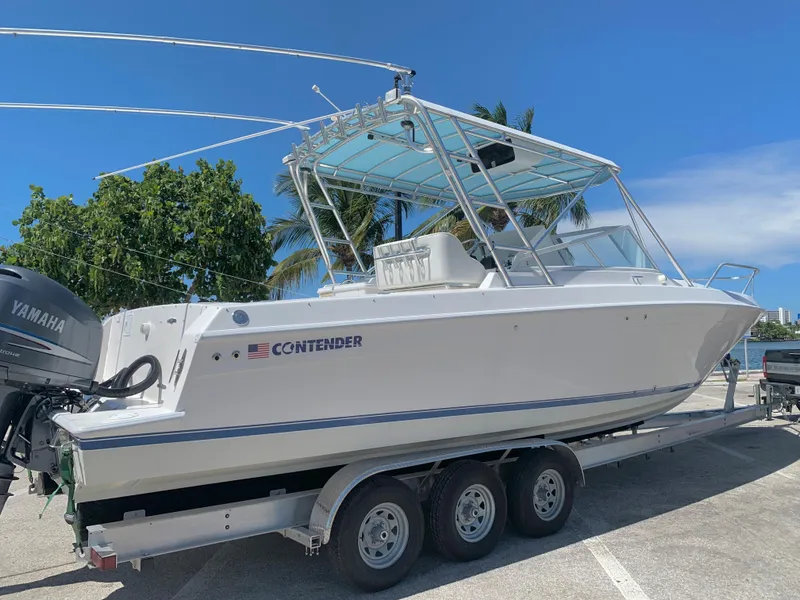 Slide: The Image of 2003 Contender 35 Express Side Console boat on a trailer with Yamaha outboard engines. - 30