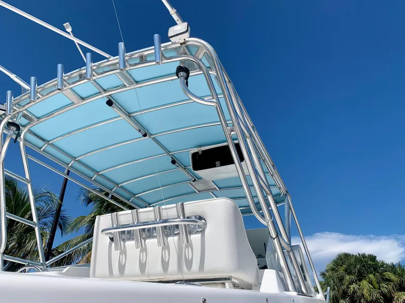 Slide: The Image of 2003 Contender 35 Express Side Console boat with blue canopy and rod holders. - 31