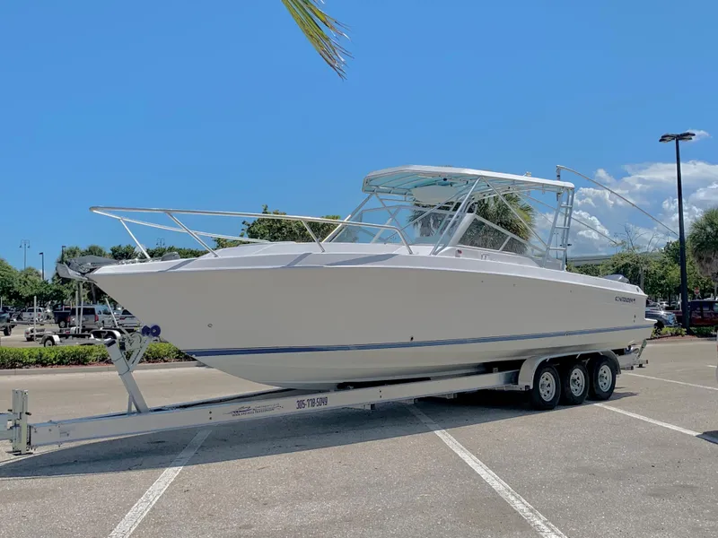 Slide: The Image of 2003 Contender 35 Express Side Console boat on a trailer in a parking lot. - 4