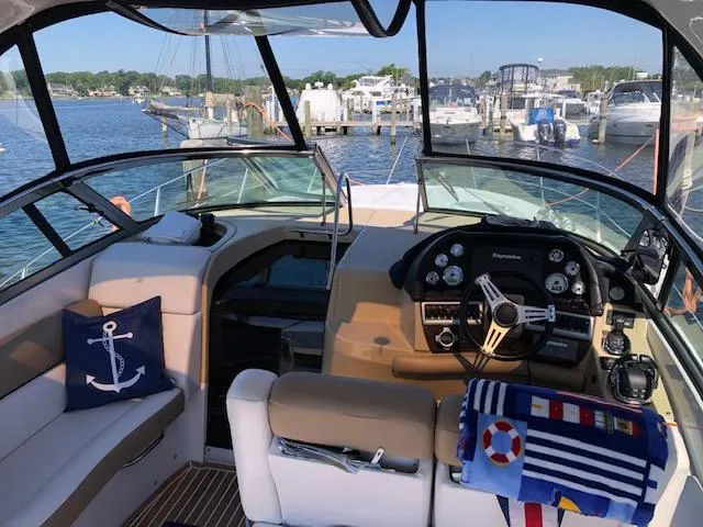 Slide: The Image of 2014 Four Winns 355V boat interior with helm, seating, and marina view. - 14