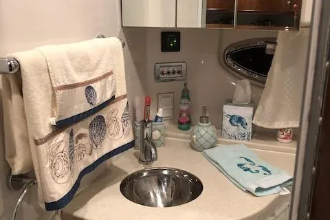 Slide: The Image of 2014 Four Winns 355V boat bathroom with sink, towels, and toiletries. - 22