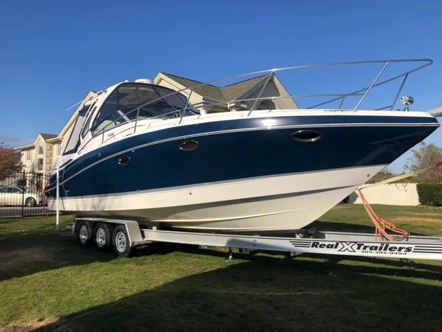 Slide: The Image of 2014 Four Winns 355V boat on Real X Trailers, parked on grass. - 3