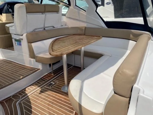 Slide: The Image of 2014 Four Winns 355V boat interior with cushioned seating and wooden table. - 38