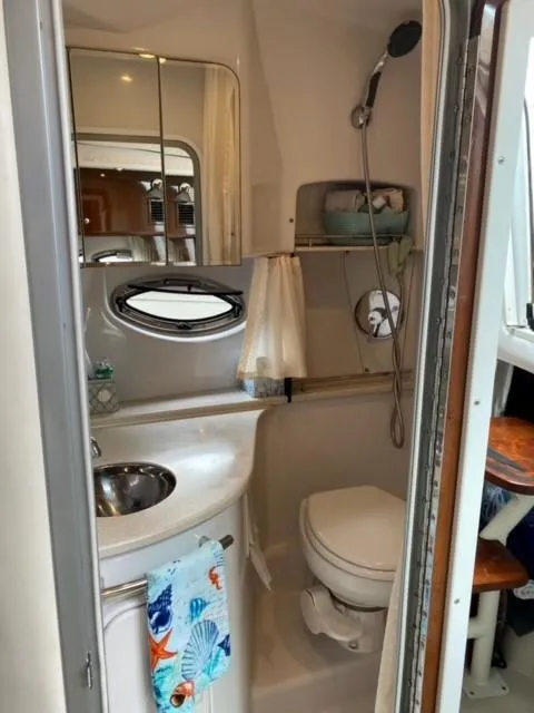 Slide: The Image of 2014 Four Winns 355V boat bathroom with sink, toilet, and shower. - 45
