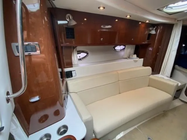 Slide: The Image of 2014 Four Winns 355V yacht interior with beige sofa and wooden cabinetry. - 48