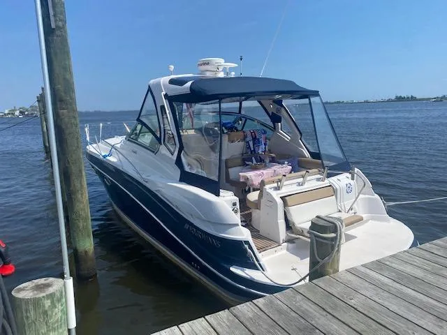 Slide: The Image of 2014 Four Winns 355V boat docked at a marina on a sunny day. - 6