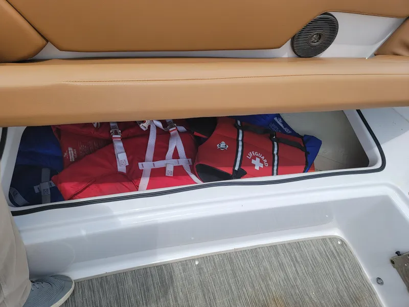 Slide: The Image of Storage compartment with life jackets on a 2019 Glastron GTD 220 boat. - 24