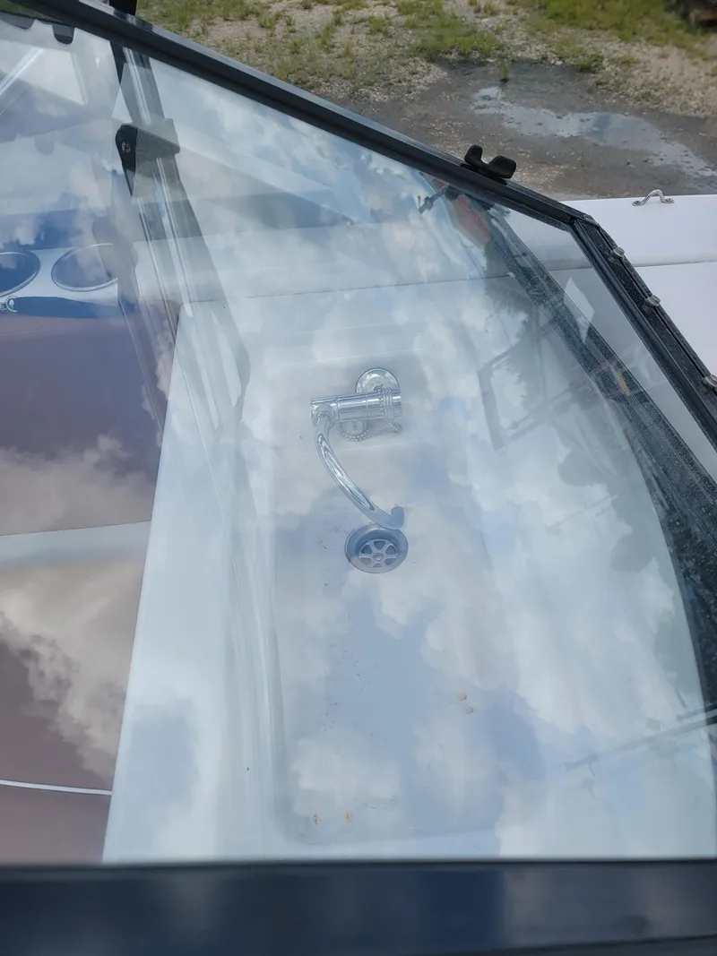 Slide: The Image of 2019 Glastron GTD 220 boat windshield with a reflection of the sky. - 25