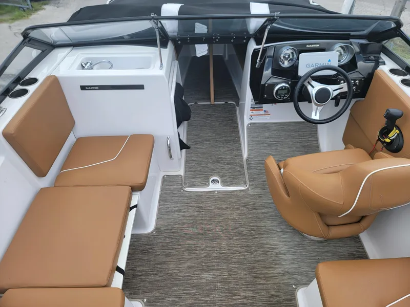 Slide: The Image of 2019 Glastron GTD 220 boat interior with tan seats and modern dashboard. - 5