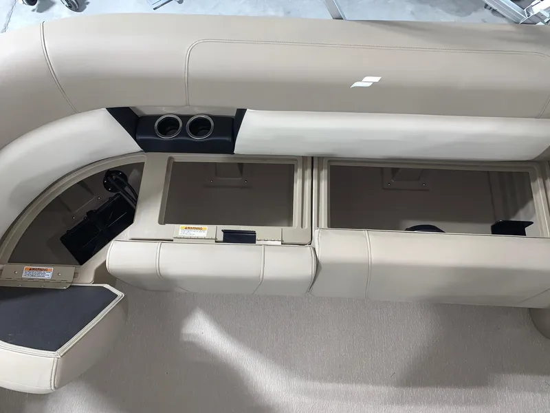 Slide: The Image of 2024 Starcraft LX22 R boat interior with storage compartments and cup holders. - 6
