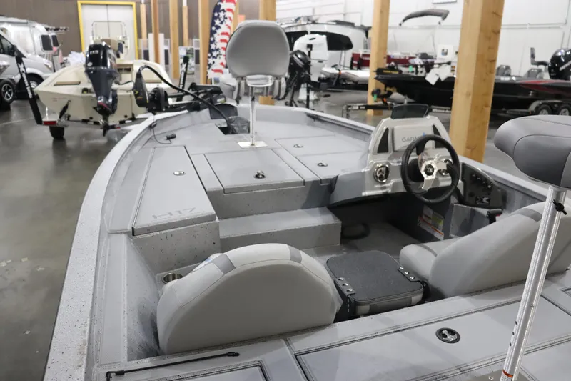 Slide: The Image of 2023 Xpress H17 fishing boat interior with steering console and seating in showroom. - 2