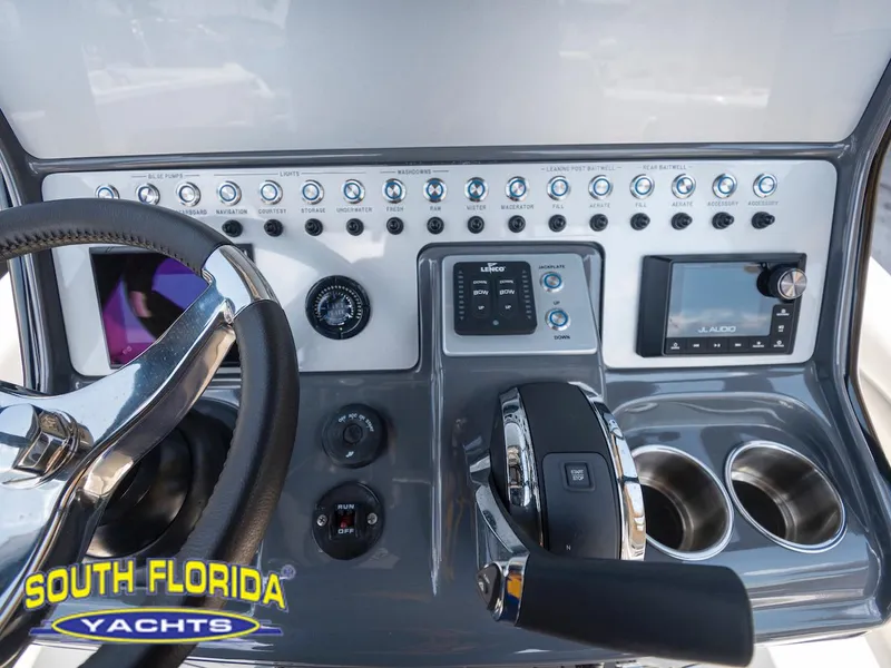 Slide: The Image of Control panel of 2023 ShearWater 260 Carolina SS boat with steering wheel and switches. - 22