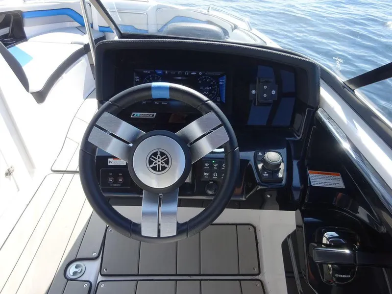 Slide: The Image of 2020 Yamaha Boats 242 X steering wheel and dashboard controls on water. - 12