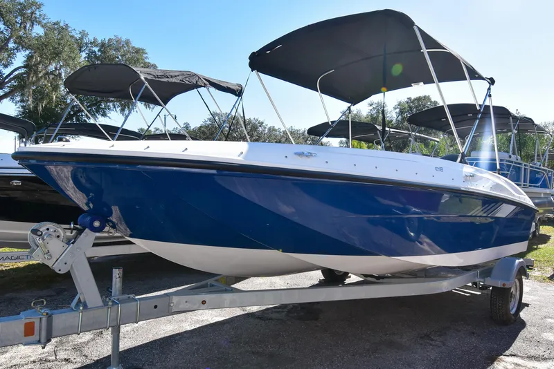 Slide: The Image of 2025 Bayliner E18 boat with blue hull on trailer, featuring black canopy. - 1