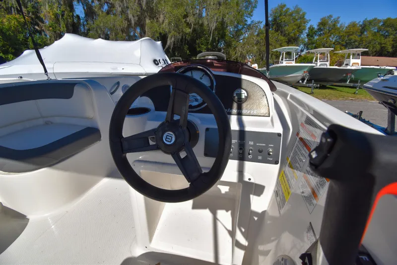 Slide: The Image of 2025 Bayliner E18 boat cockpit with steering wheel and control panel. - 9