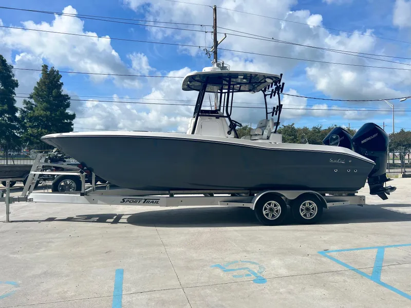 Slide: The Image of 2023 Sea Cat 262 HC boat on trailer with twin engines, parked outdoors. - 5