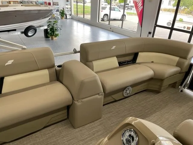 Slide: The Image of 2023 Starcraft LX 16 R pontoon boat interior with beige seating in showroom. - 11