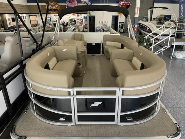 Slide: The Image of 2023 Starcraft LX 16 R pontoon boat with beige seating in showroom. - 3