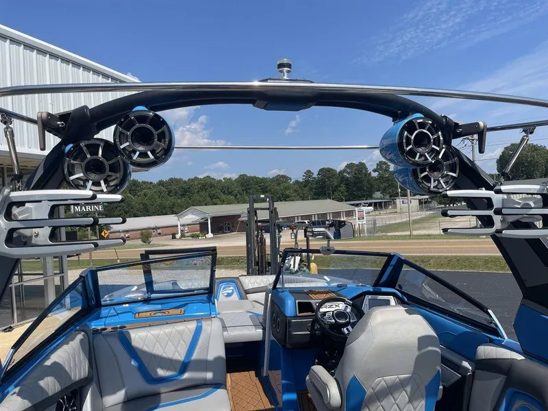 Slide: The Image of 2017 Tigé RZX2 boat interior with blue and gray seating, tower speakers, and steering console. - 3