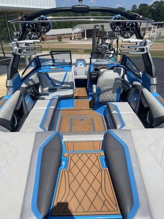 Slide: The Image of 2017 Tigé RZX2 boat interior with blue and gray seating, advanced sound system, and teak flooring. - 5