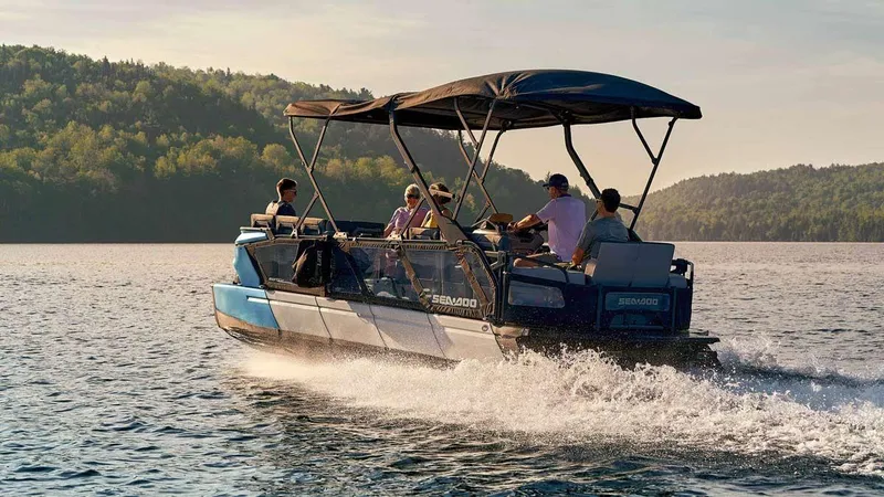Slide: The Image of 2023 Sea-Doo Switch Cruise 21 - 170 Hp on a scenic lake with passengers. - 2