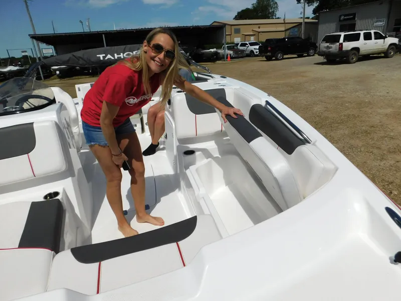Slide: The Image of Woman exploring a 2023 Tahoe 1950 boat at a dealership. - 19