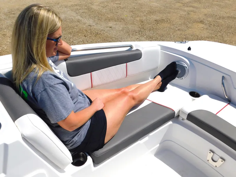 Slide: The Image of Woman relaxing on a 2023 Tahoe 1950 boat with grey and white seating. - 20