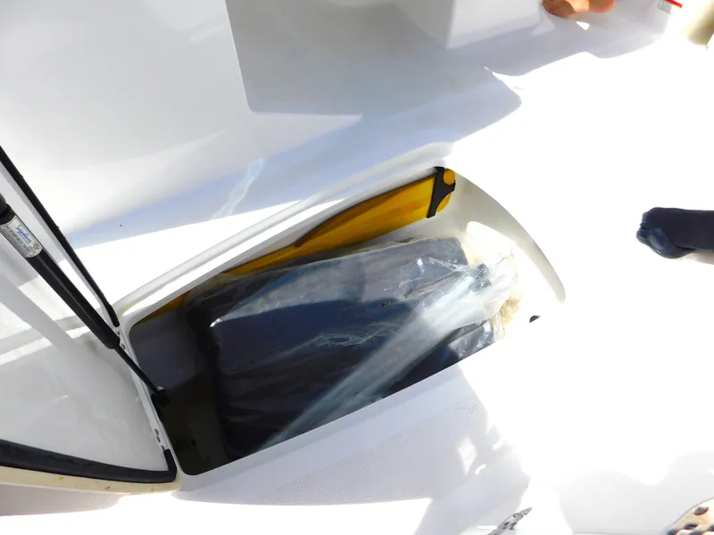 Slide: The Image of Storage compartment of a 2023 Tahoe 1950 boat with a covered item inside. - 30