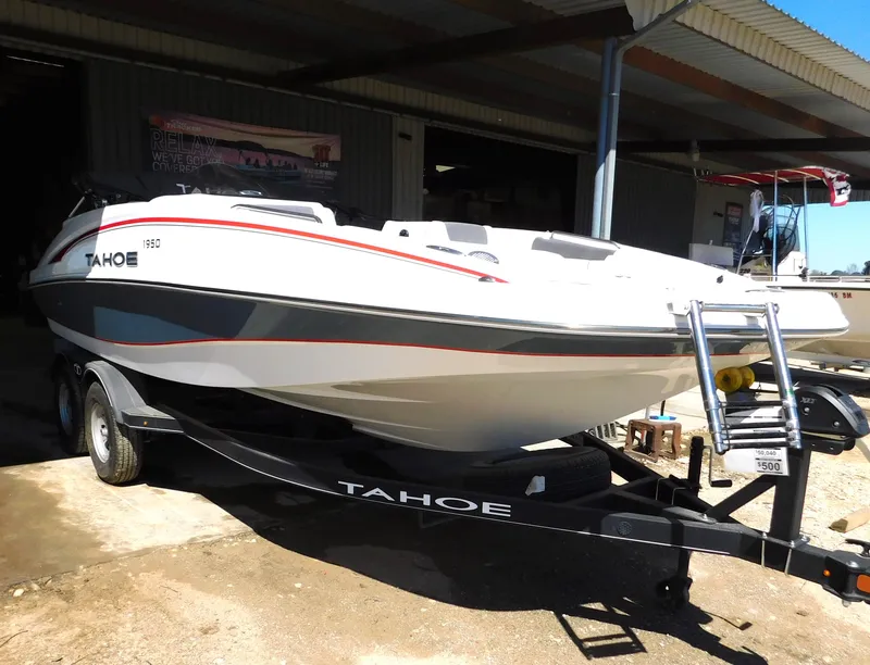 Slide: The Image of 2023 Tahoe 1950 boat on trailer in front of a shed. - 36