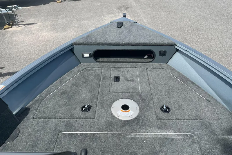 Slide: The Image of 2023 Starcraft Storm 166 DC boat interior with carpeted deck and storage compartments. - 10