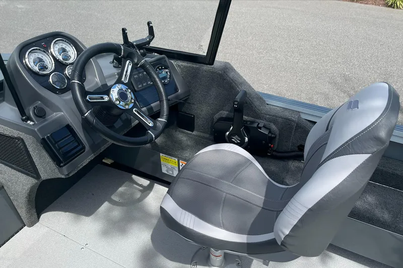 Slide: The Image of 2023 Starcraft Storm 166 DC boat cockpit with steering wheel and captain's chair. - 6
