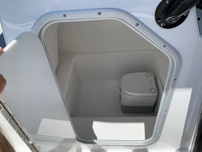 Slide: The Image of 2024 Cape Horn 24 XS boat interior storage compartment with portable toilet. - 9