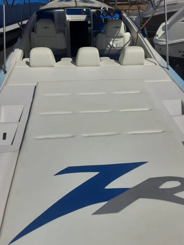 Slide: The Image of 2006 Donzi 43 ZR speedboat interior with white seating and blue dashboard. - 10