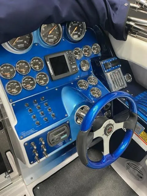 Slide: The Image of 2006 Donzi 43 ZR boat dashboard with blue accents and multiple gauges. - 4