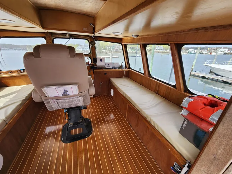 Slide: The Image of Interior of 1980 Tuna Rose Brothers boat with wooden flooring and seating, docked at marina. - 11