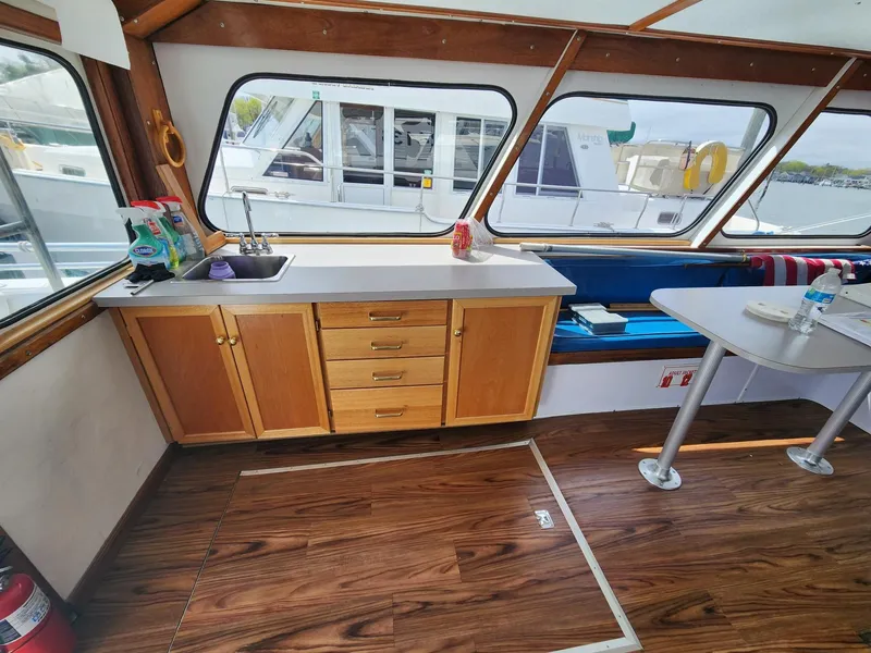 Slide: The Image of Interior of 1980 Tuna Rose Brothers boat with wooden cabinets and seating area. - 19