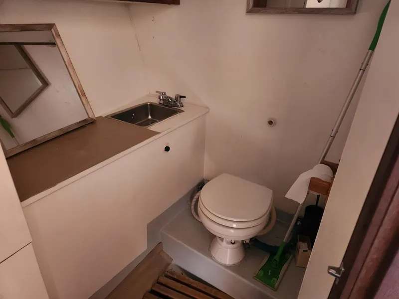 Slide: The Image of Compact bathroom in a 1980 Tuna Rose Brothers boat, featuring a sink and toilet. - 25