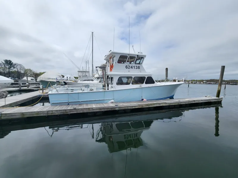 Slide: The Image of 1980 Tuna Rose Brothers boat docked at a marina, reflecting on calm water. - 3
