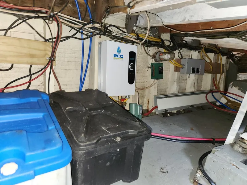 Slide: The Image of Basement utility area with wiring, storage boxes, and an ECO water heater, Tuna Rose Brothers 1980. - 36