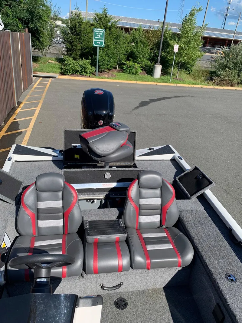 Slide: The Image of 2021 Ranger RT188C boat with gray and red seats in a parking lot. - 7