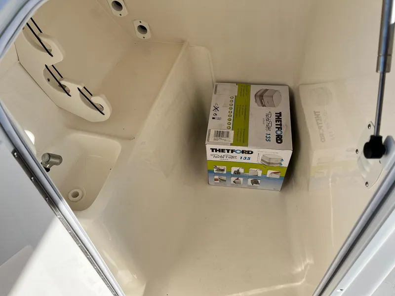 Slide: The Image of 2024 Key West 239 DFS storage compartment with Thetford portable toilet. - 18