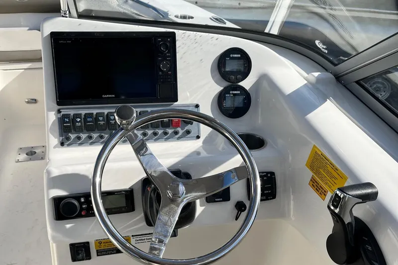 Slide: The Image of 2024 Key West 239 DFS boat dashboard with steering wheel and control panel. - 5